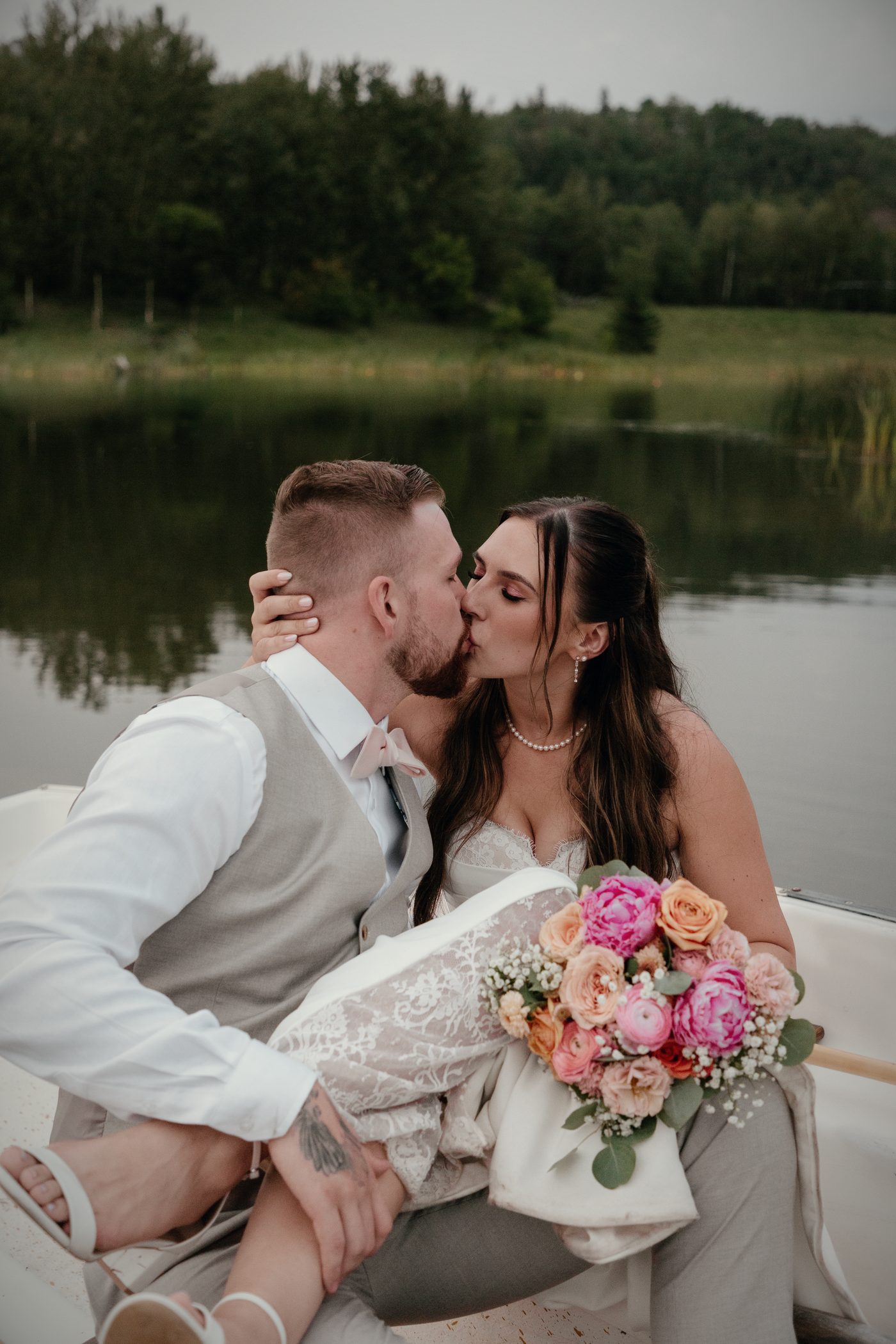 A kiss in the rowboat, a bouquet of pink and peach roses in her lap