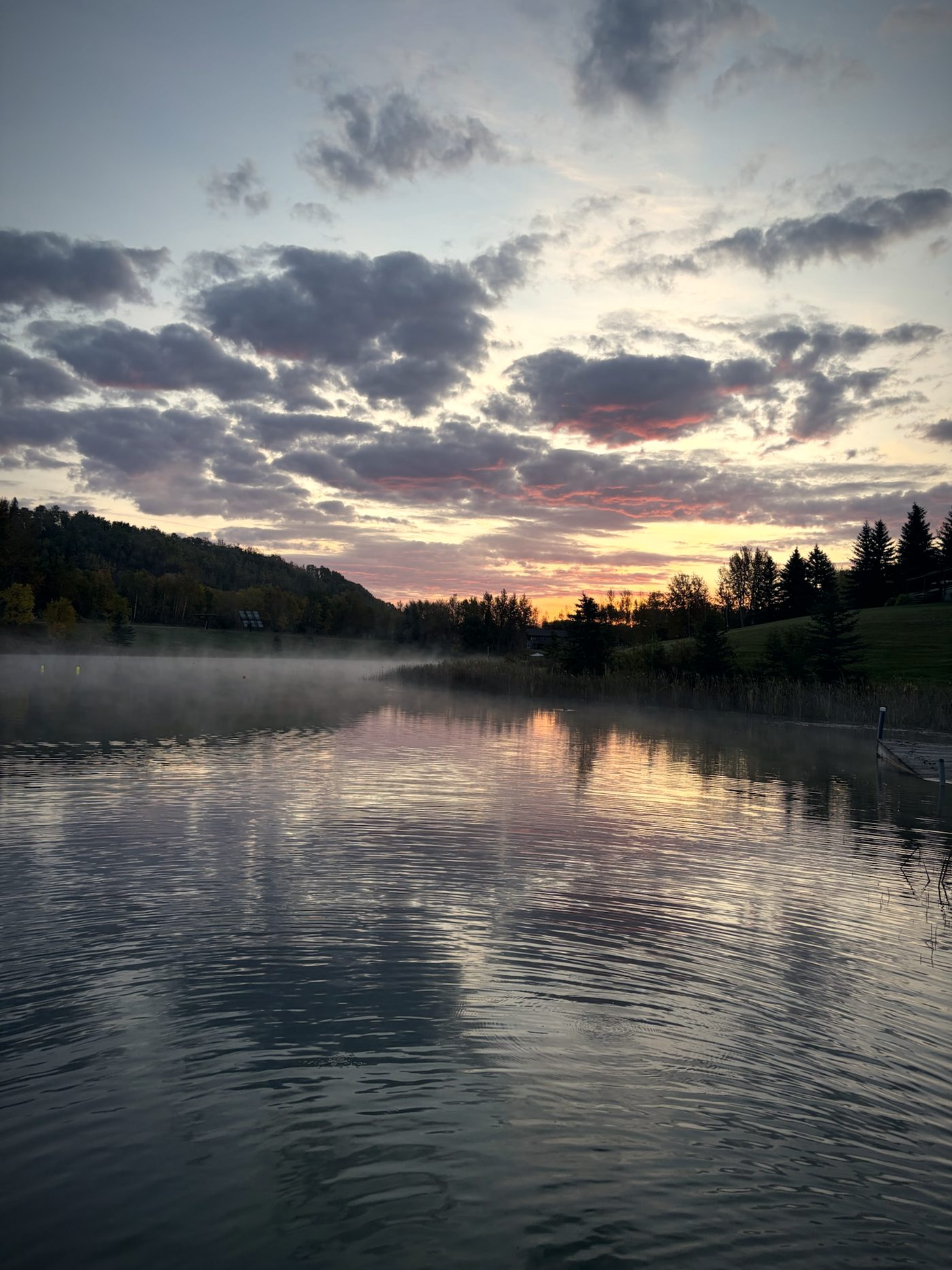 The lake at dawn, mist on the water and the sky turning pink
