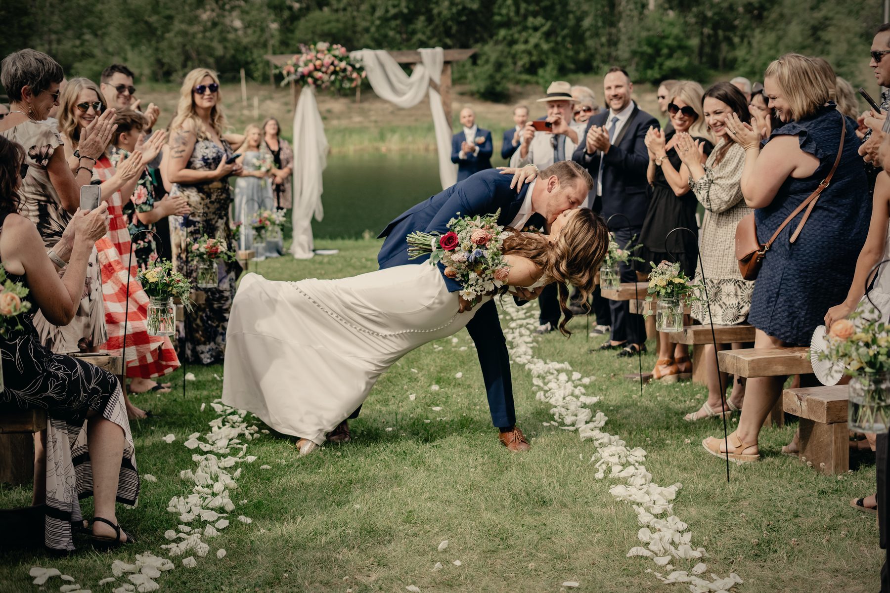 The couple's recessional down the petal aisle, the groom dipping the bride in front of the guests
