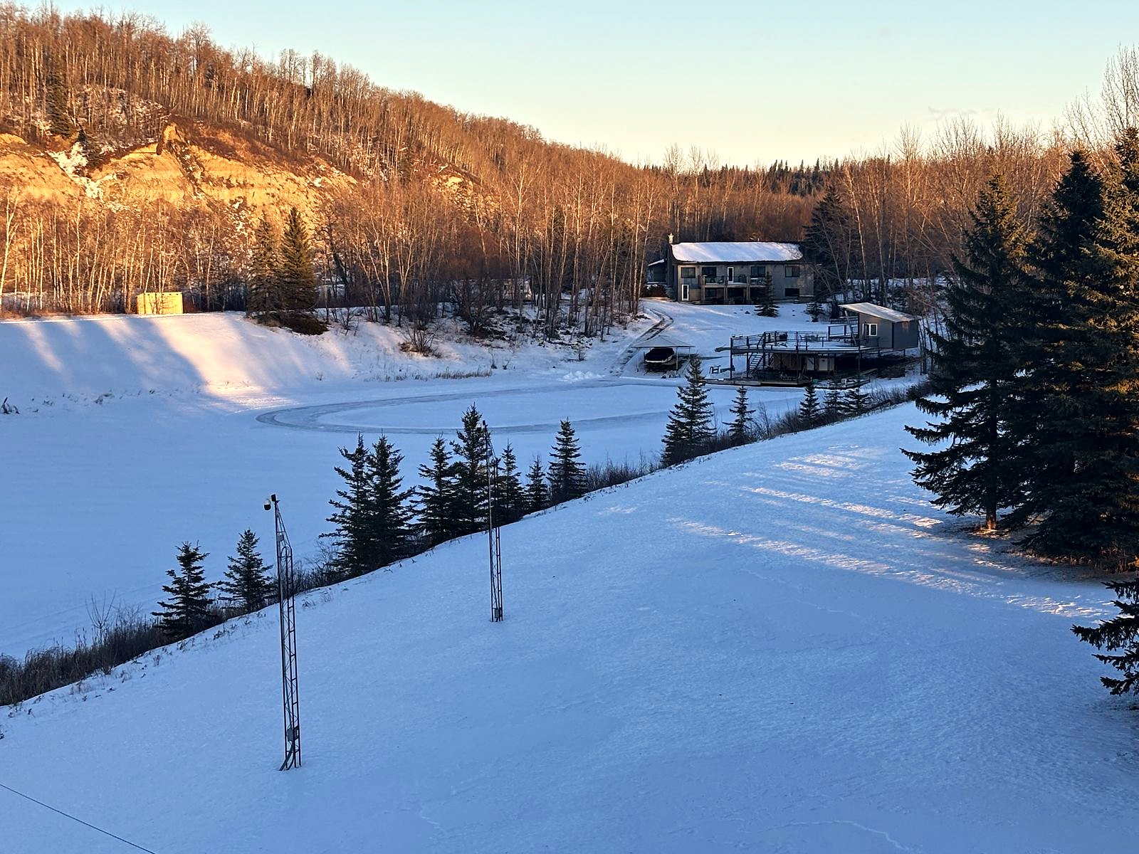 The valley in winter, the frozen lake, the spruce, and the family house up on the far slope