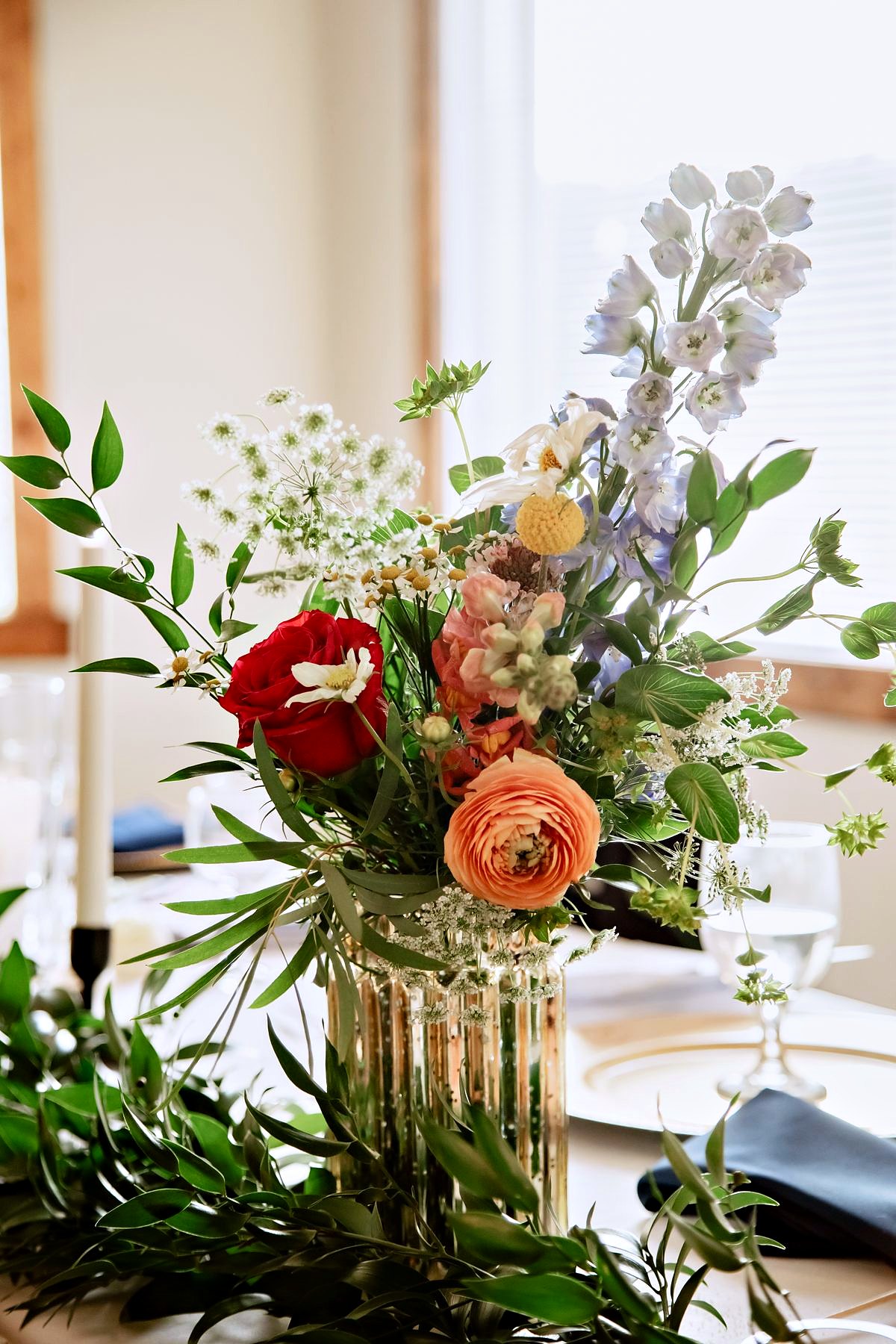 A table arrangement in the hall, garden roses, ranunculus and olive