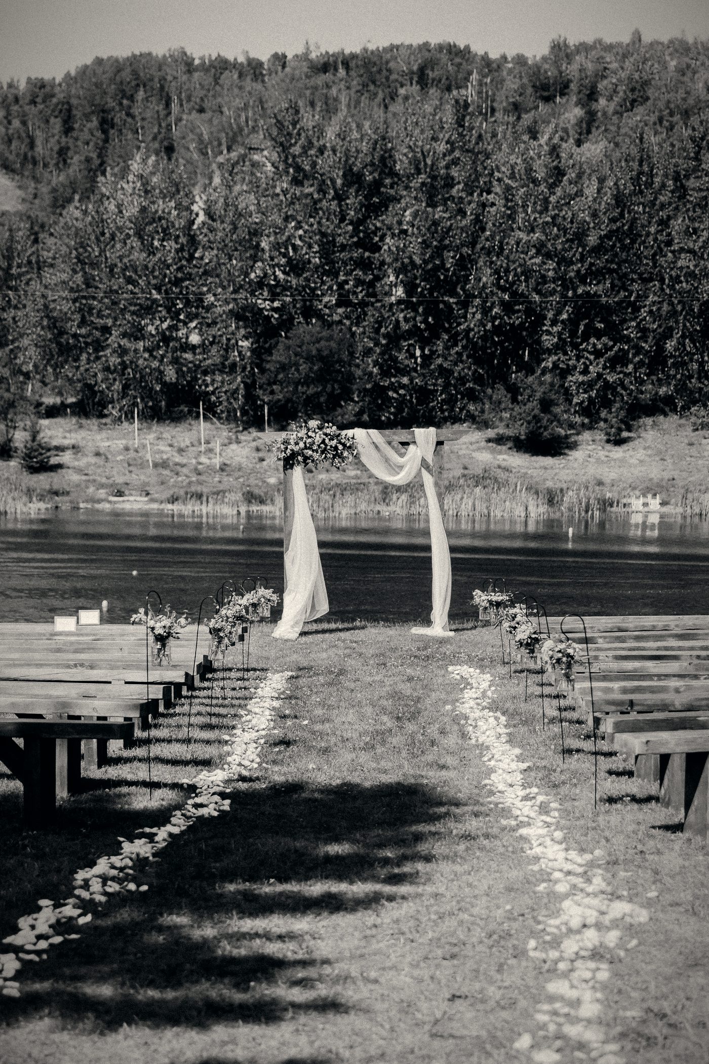 The aisle at eye height, running between the benches to the arbour with the water behind
