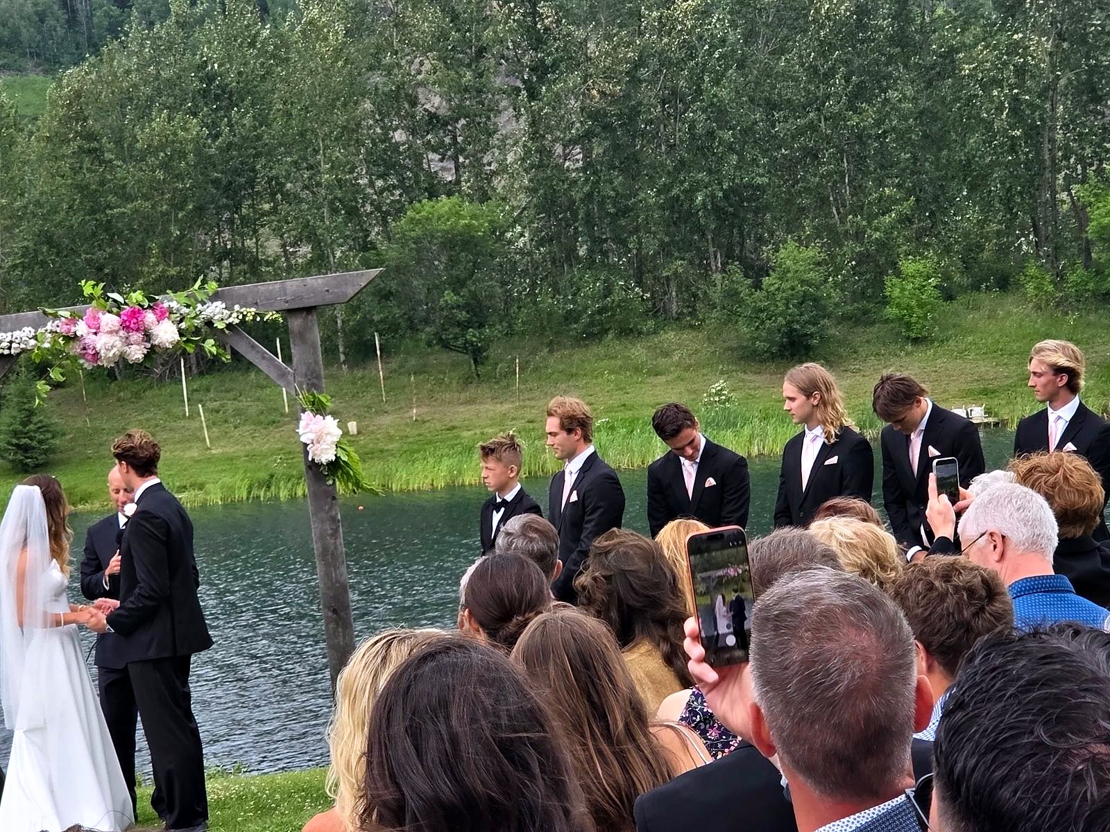 The ceremony from among the guests, the arbour and the lake beyond