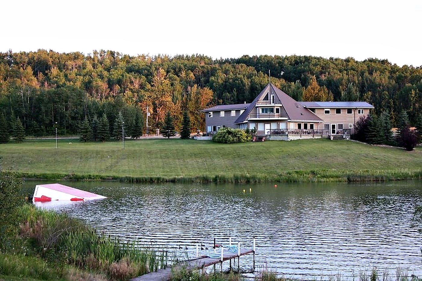 The hall seen across the lake in late September, the aspen on the slope turned gold and the water dark and flat